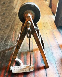 Treadle powered lathe on a triangular stand with James L Lord written on the pedal