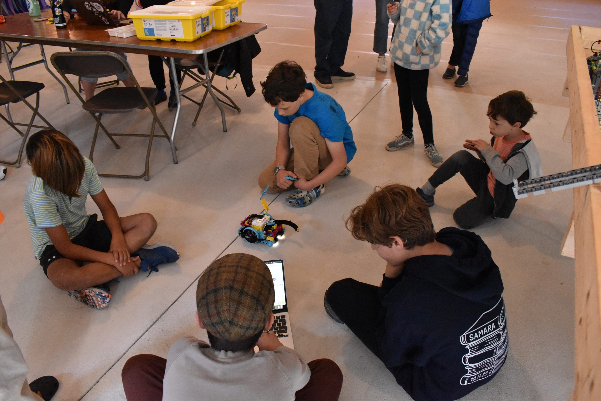 Kids gathered around a robot build at Robo Jam 2