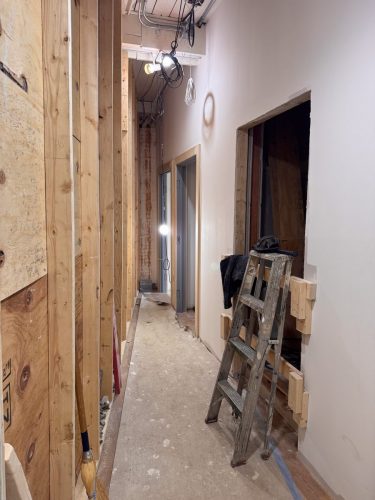 Behind the lobby wall, a stairwell to the basement, a closet, and the elevator shaft (Feb 2026)